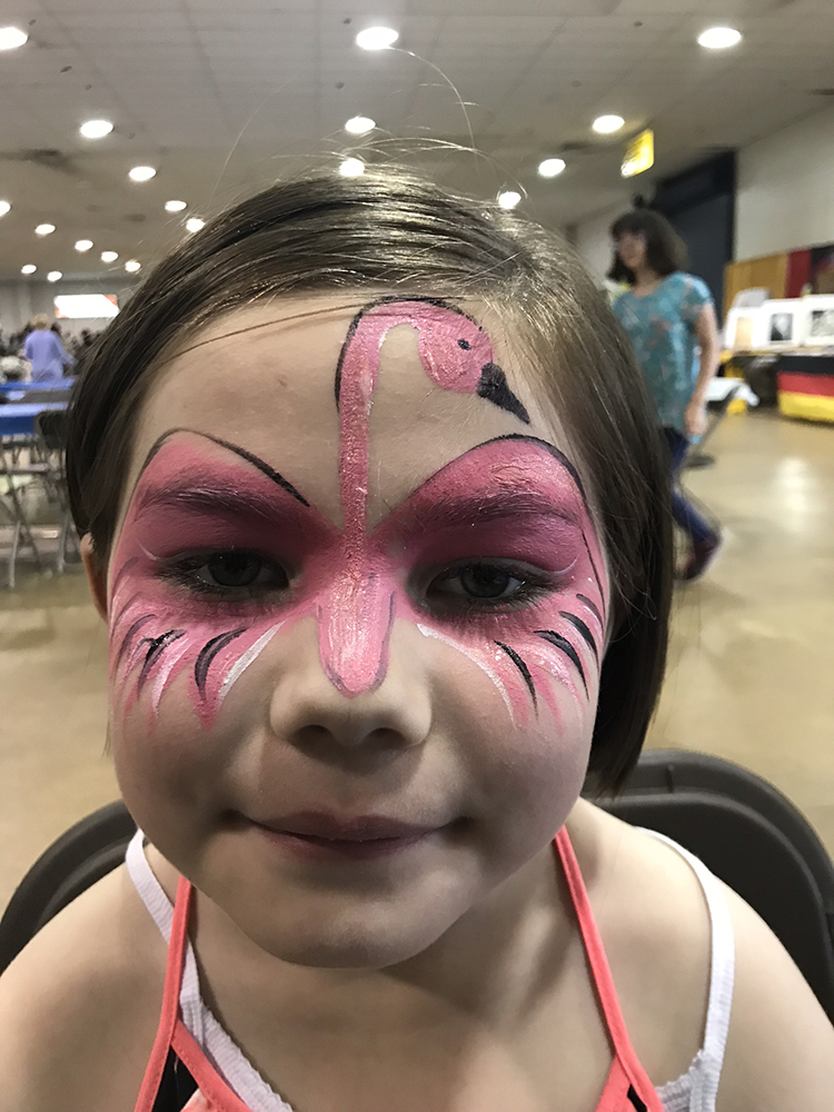 Girl with a flamingo painted on her face