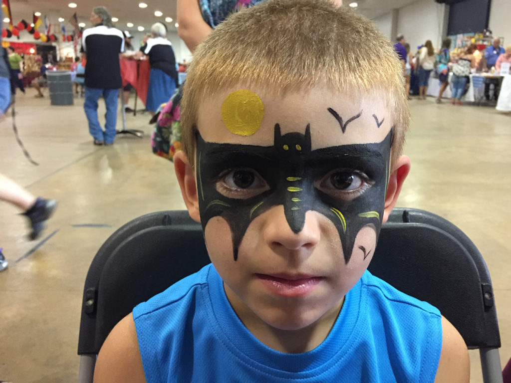 Boy painted with a Batman mask